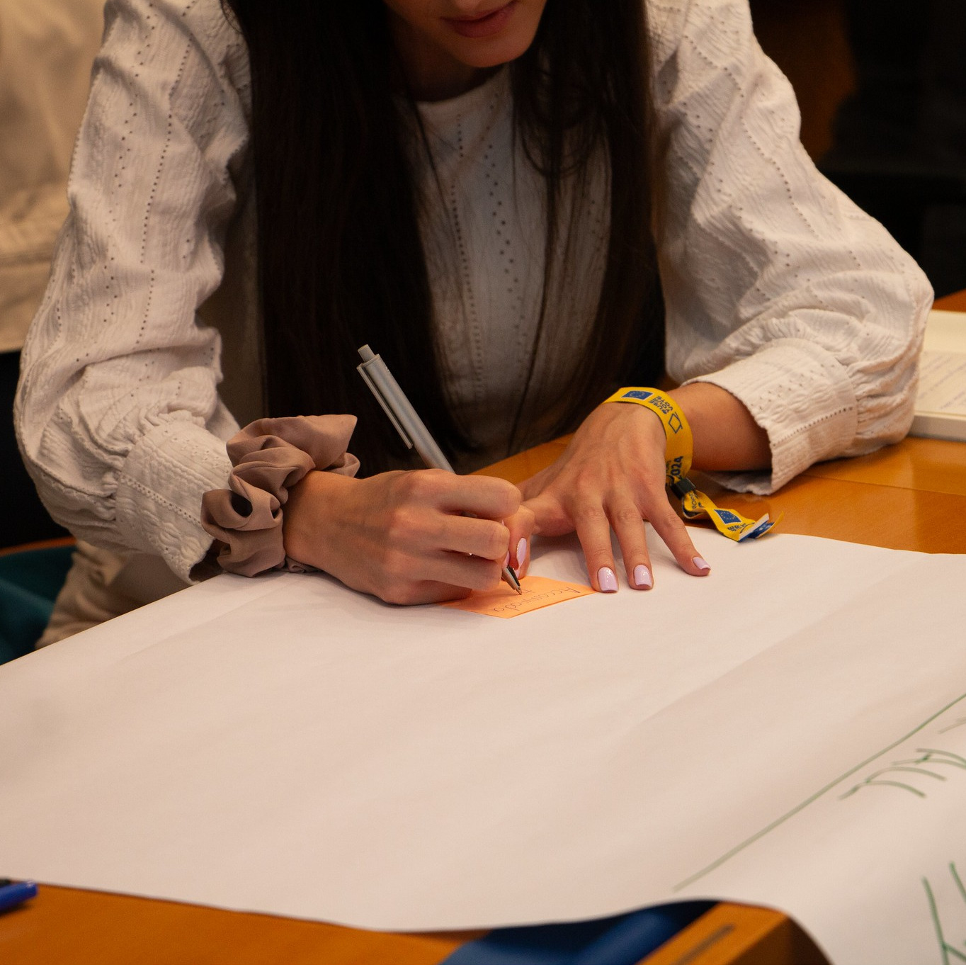 Image of a person writing on a flipchart at a desk.