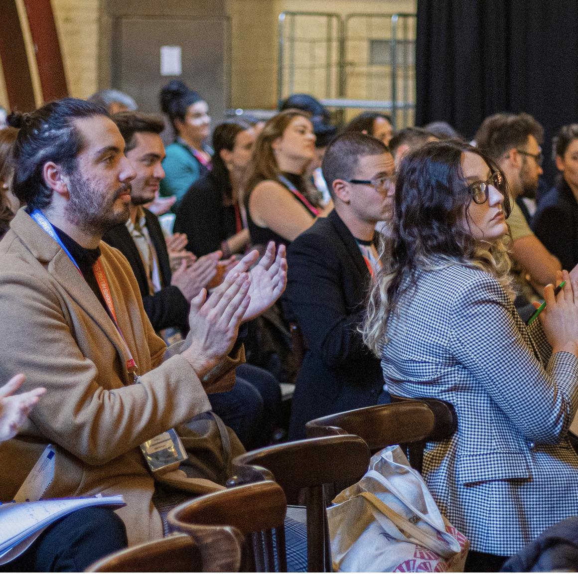 Image of a people applauding at a conference.